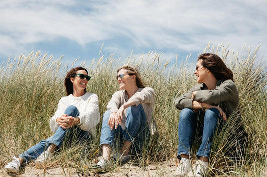 SISTERLY founders Aoife, Jenny and Louise sitting together in the dunes on the beach